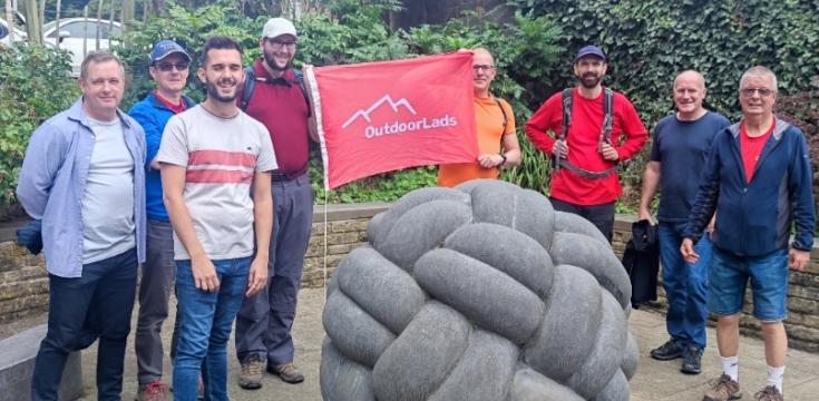 ODL members with red flag behind a sculpture of a knitted ball